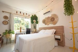 ein Schlafzimmer mit Bett, Schreibtisch und Fenster in der Unterkunft Aconchego e Incrível Vista Mata Santa Teresa Wi-fi 500Mega in Rio de Janeiro