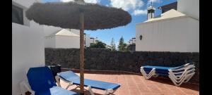 two chairs and an umbrella on a patio at Suite Bucica in Teguise