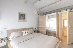 Habitación blanca con cama y ventana en Les Lauriers en Lubéron, en Cheval Blanc