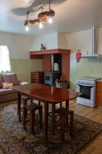 cocina con mesa de madera y sillas en una habitación en Casa Mourato, en Alpedriz