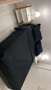 uma cama com um edredão preto num quarto em Lugar perfecto em Mar del Plata