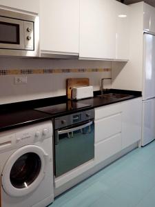 una cucina bianca con lavatrice e lavastoviglie di Apartamento Estelas de Cantabria a Los Corrales de Buelna