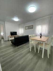 ein Wohnzimmer mit einem Tisch, Stühlen und einem Sofa in der Unterkunft piso junto al hospital macarena in Sevilla
