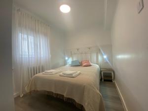 1 dormitorio con 1 cama con 2 toallas en piso junto al hospital macarena en Sevilla