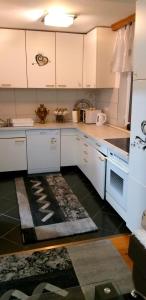 a kitchen with white cabinets and a rug on the floor at Apartmani GS ***** Zavidovici in Zavidovići