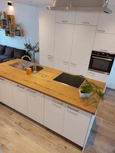 a kitchen with white cabinets and a wooden counter top at Aux six fontaines in Herve