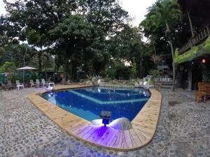 una piscina con un camino de madera alrededor en EcoHostal Rio Piedra, en El Zaino