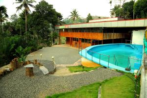 a building with a large blue pool in front of it at AYURGREEN HERITAGE in Kattappana