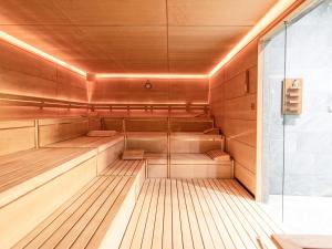 a sauna with wood paneling and a glass wall at Kitzbühel Residences in Kitzbühel +35 photos