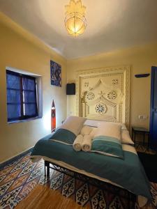 um quarto com uma cama grande com uma cabeceira grande em Cactus rooms em Chefchaouene