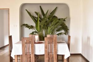 a dining room with a table with a potted plant at Villa paisible proche des rizières in Antananarivo