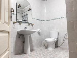 uma casa de banho branca com um lavatório e um WC em Hill View Hotel West Airport em Accra
