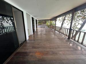 an empty porch of a house with a wooden walkway at Haad Chao Phao Resort in Haad Chao Phao