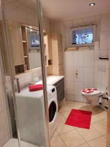 a bathroom with a washing machine and a toilet at Ferienwohnung Mohnblume in Rosdorf +17 photos
