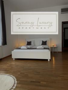 ein Schlafzimmer mit einem weißen Bett mit einem Schild darüber in der Unterkunft Saray Luxury in Sarajevo