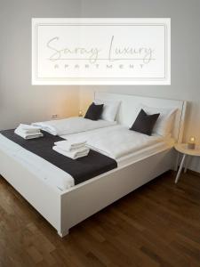 Un dormitorio con una cama blanca con un letrero encima. en Saray Luxury, en Sarajevo