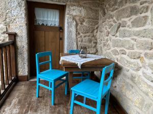 a table and two blue chairs on a patio at Casa Garcia - Chaves in Chaves