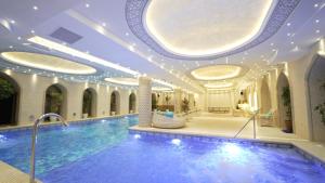 a large swimming pool in a building with a ceiling at Karvon-Saroy Hotel in Andijan