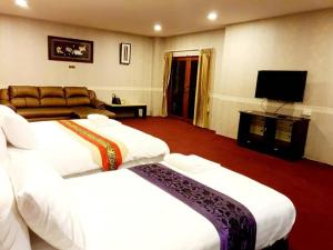 a hotel room with two beds and a flat screen tv at Raya Ville in Amphoe Koksamui