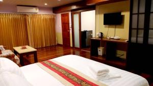 a hotel room with a bed and a television at Raya Ville in Nathon Bay