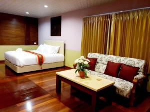 a bedroom with a bed and a couch and a table at Raya Ville in Nathon Bay