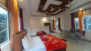 1 dormitorio con cama, mesa y ventanas en Himadri munnar holidays en Munnar
