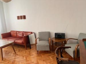 - un salon avec un canapé, des chaises et une table dans l'établissement Apartment August 11, à Sofia