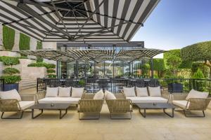 a patio with white couches and chairs under a canopy at Grand Hyatt Amman Residences in Amman