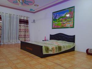 una camera da letto con un letto e un quadro sul muro di Mir manzil a Srinagar