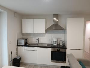 a kitchen with white cabinets and a stove top oven at Un bon momentde dente in Bonneville