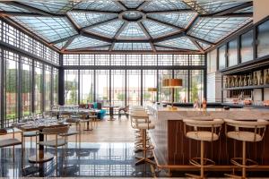 アンマンにあるGrand Hyatt Amman Residencesのバー付きのレストラン、テーブルと椅子