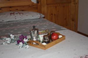 un vassoio di cibo e frutta su un letto di Casa Longa a Livigno
