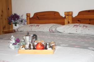リヴィーニョにあるCasa Longaのベッドの上に食品と果物のトレイ