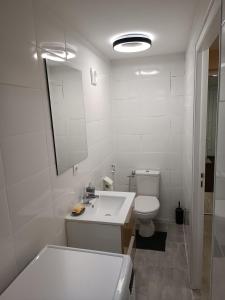a white bathroom with a sink and a toilet at Un bon momentde dente in Bonneville