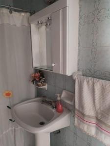 y baño con lavabo y espejo. en Apartamento con quincho y parrilla en Mar del Plata