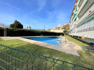 貝納加爾彭塔的住宿－Apartamento Nebro el Rincón，一座游泳池,位于一座建筑旁的院子内