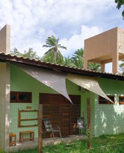 una casa verde con techo blanco en Cafofo de Dri en Ilha de Boipeba