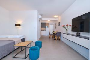 a bedroom with a bed and a table and a kitchen at House Torre Apartments in Mali Lošinj