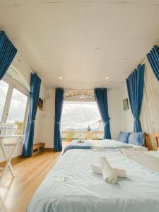 1 Schlafzimmer mit 2 Betten und einem großen Fenster in der Unterkunft Nắng Hiên Nhà Villa - Homestay Đà Lạt in Khu Chi Lăng