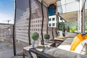 a balcony with a couch and potted plants on a building at Spacious modern 2BR apartment at Central OSLO BARCODE in Oslo
