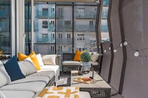 a patio with couches and a table on a balcony at Spacious modern 2BR apartment at Central OSLO BARCODE in Oslo