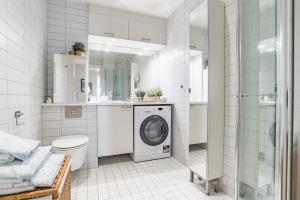 a bathroom with a washing machine and a toilet at Spacious modern 2BR apartment at Central OSLO BARCODE in Oslo