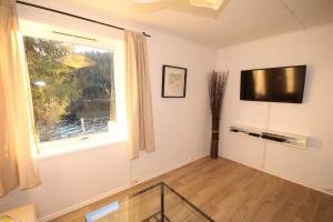 a living room with a large window and a flat screen tv at Herøya Porsgrunn Apartment in Porsgrunn