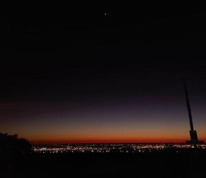 a view of a city at night with the moon at Casa Cerro Arco in Mendoza