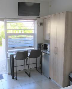 a kitchen with a table and chairs and a window at Pro Moni's Guesthouse in Muizenberg