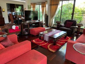 sala de estar con muebles de color rojo y TV de pantalla plana en HomeSweetHome, en Hang Dong
