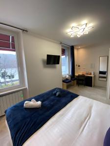 - une chambre avec un grand lit et 2 serviettes dans l'établissement Hôtel-restaurant La bonne hôtesse, à Chambon-sur-Lac