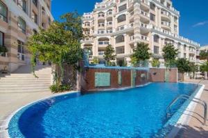 a large blue swimming pool in front of a building at Sky & Sea Apartment in Golden Sands