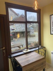einen Tisch und ein Fenster mit Blick auf eine Scheune in der Unterkunft Uist Cottage in Kingussie