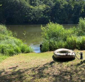 a boat sitting on the grass next to a body of water at Nature Lodge Csesztve in Csesztve